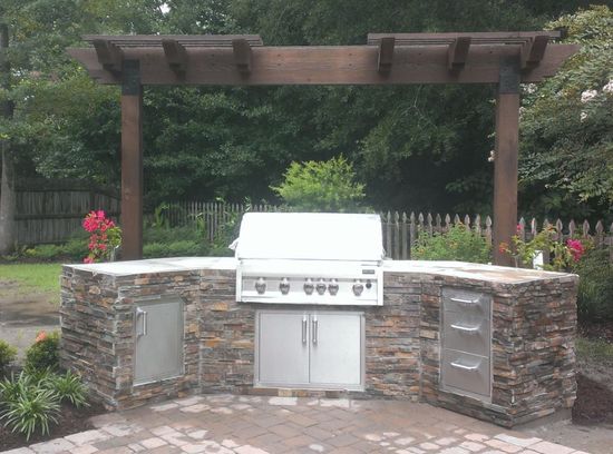 A White Color Grill Unit With Cover on Rock Paneled Platform